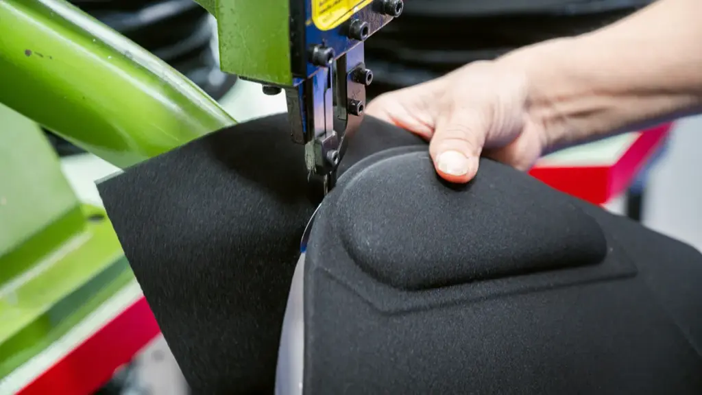 Close-up of a worker stitching black pad with sewing machine