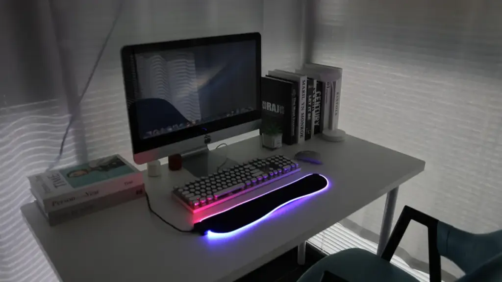 Minimalist white desk setup with an illuminated RGB wrist rest
