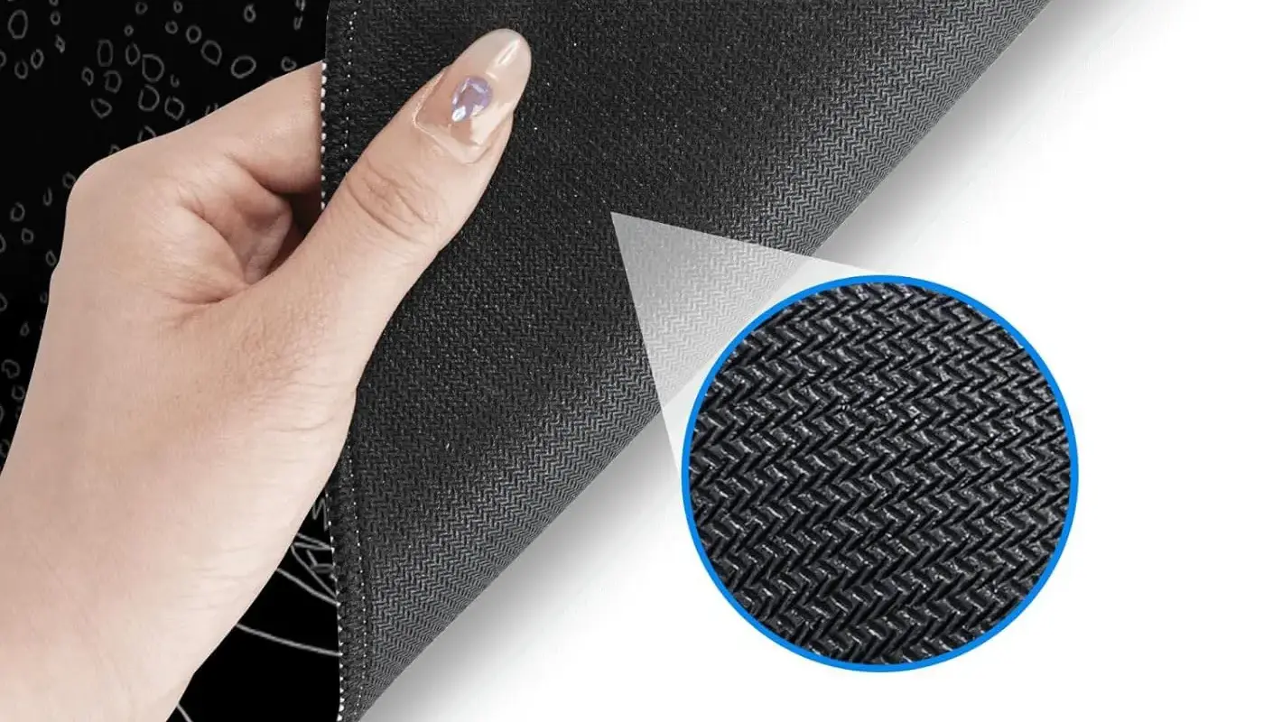 Hand lifting mousepad corner showing non-slip herringbone textured bottom with magnified detail view